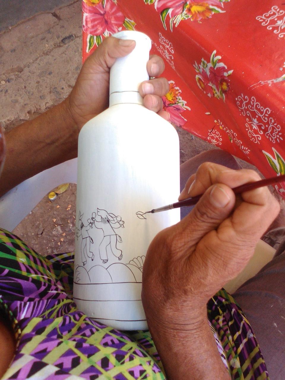 Artesana pintando a mano una pieza ALMMA